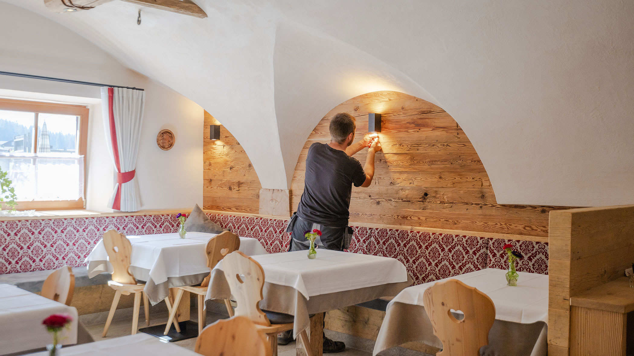 Elektriker montiert eine Lampe in einem Restaurant - Elektro Felderer